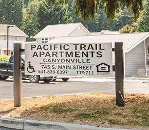 Canyonville apartment for rent - a sign for pacific trail apartments in front of a truck