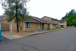 Elma apartment for rent - a row of houses with a tree in the middle of the road