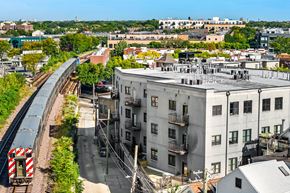 Chicago apartment for rent - A train is coming down the tracks in a city.