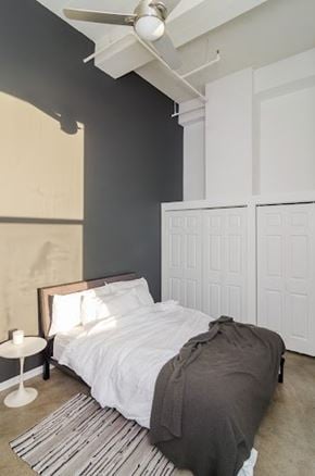 Minneapolis apartment for rent - A bedroom with a bed, a nightstand, and a ceiling fan.