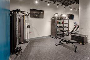 Minneapolis apartment for rent - A gym with a weight rack, a bench, and a row of dumbbells.