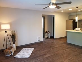 Auburn apartment for rent - an empty living room with a ceiling fan and a kitchen