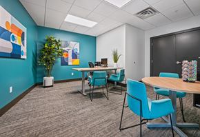 Minneapolis apartment for rent - an open office space with tables and chairs and a blue wall