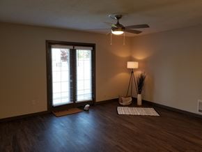 Auburn apartment for rent - an empty living room with a ceiling fan and a window