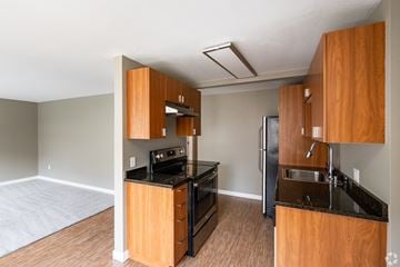 Seattle apartment for rent - A kitchen with wooden cabinets and black appliances.