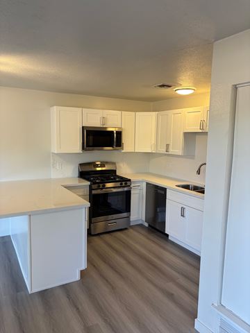 Tucson apartment for rent - A kitchen with white cabinets and a stove top oven.