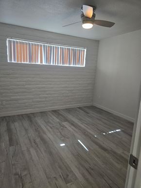 Tucson apartment for rent - A room with a ceiling fan and a window with blinds.