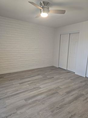 Tucson apartment for rent - A room with a ceiling fan and a wooden floor.