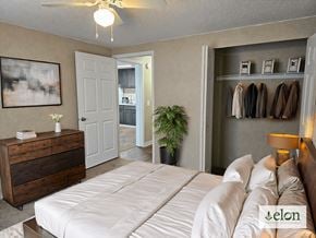 Lilburn apartment for rent - A bedroom with a bed, dresser, and coat rack.