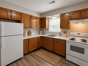 Indianapolis townhouse for rent - A kitchen with wooden cabinets and a white refrigerator.