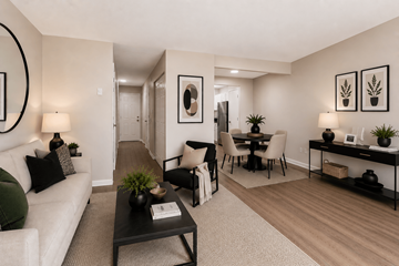Indianapolis apartment for rent - A living room with a white couch, a black coffee table, and a dining area with a table and chairs.