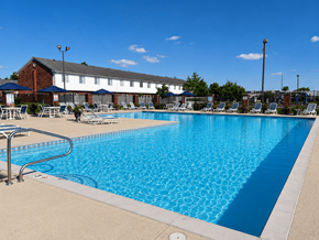 Indianapolis apartment for rent - A large blue swimming pool with a metal railing on the left side.