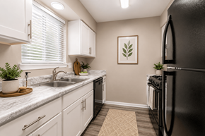 Indianapolis townhouse for rent - A kitchen with white cabinets and a black refrigerator.