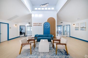 Naples apartment for rent - a living room with a blue couch and chairs and a white table
