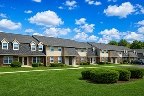 Indianapolis apartment for rent - A row of houses with green lawns in front.