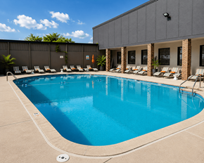 Indianapolis apartment for rent - A large swimming pool with lounge chairs and a building in the background.