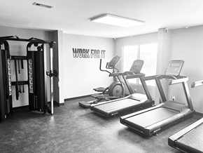 Homewood apartment for rent - A black and white photo of a gym with treadmilers, weights, and a sign that says "Work for It".