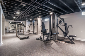 Westland apartment for rent - A spacious gym with a variety of equipment including a leg press machine, a chest press machine, and a bench press.