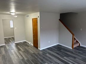 Cleveland townhouse for rent - a empty living room with a wooden floor and a staircase