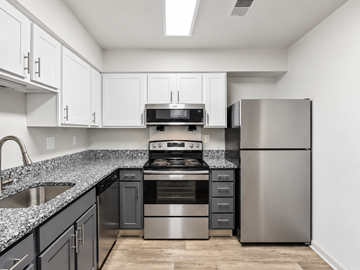 Indianapolis apartment for rent - A kitchen with a stainless steel refrigerator and a black and white counter.