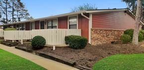 Franklin apartment for rent - A red and white mobile home with a white fence and green bushes.
