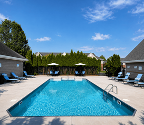 Columbus apartment for rent - A large swimming pool surrounded by lounge chairs and umbrellas.