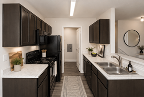 Columbus apartment for rent - A kitchen with dark brown cabinets and a black stove top oven.