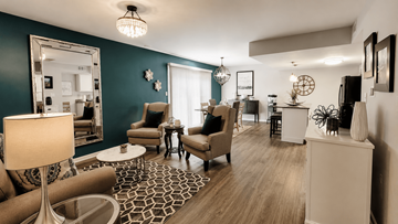New Albany apartment for rent - A living room with a patterned rug and a large mirror on the wall.