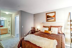Brownstown apartment for rent - A bedroom with a large bed and a painting on the wall.