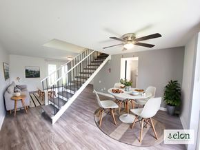 Columbus townhouse for rent - A dining room with a table set for four and a staircase at Townhomes at 28th, Columbus, Indiana