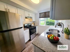 Columbus townhouse for rent - A modern kitchen with a stainless steel refrigerator and a bowl of fruit on the counter at Townhomes at 28th, Columbus, Indiana