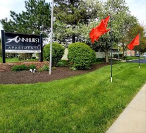 Indianapolis apartment for rent - a lawn with two red flags and a sign