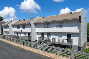 Homewood apartment for rent - A white building with a grey roof and a metal fence in front.