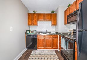 Fairfield apartment for rent - A kitchen with wooden cabinets and black appliances.