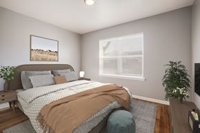 Indianapolis triplex for rent - a bedroom with a bed and a chair and a window