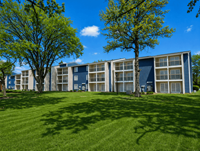 Indianapolis apartment for rent - A large grassy area in front of a building with trees on either side.