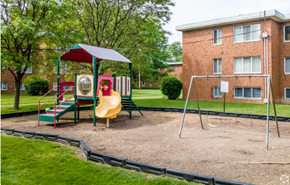 Cleveland townhouse for rent - a playground with a swing set in front of a building