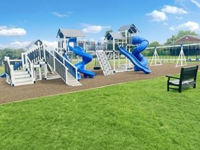 Indianapolis apartment for rent - A playground with a blue slide and a green bench.