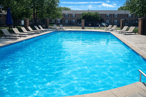 Indianapoils apartment for rent - A large blue swimming pool surrounded by lounge chairs.