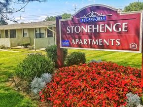 Indianapolis apartment for rent - a sign for stonehenge apartments in front of a garden