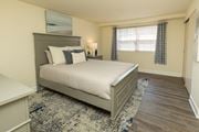 Baltimore apartment for rent - A bedroom with a large bed and a window with curtains at Colony Hill Apartments & Townhomes, Baltimore, MD