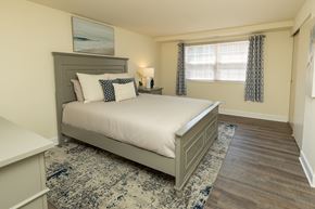 Baltimore apartment for rent - A bedroom with a large bed and a window with curtains at Colony Hill Apartments & Townhomes, Baltimore, MD