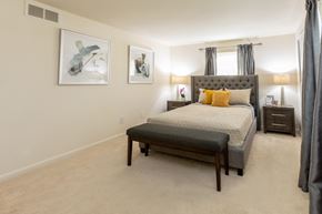 Baltimore apartment for rent - A bedroom with a large bed and two framed pictures on the wall at Spring Hill Apartments & Townhomes, Baltimore