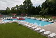Towson apartment for rent - A large outdoor swimming pool surrounded by lawn chairs and umbrellas.