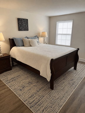 Hanover apartment for rent - A bedroom with a large bed and a patterned rug.