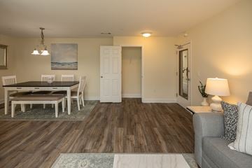 Owings Mills apartment for rent - A living room with a grey couch and a wooden floor.