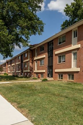 Baltimore apartment for rent - A long brick building with a green lawn in front at Winston Apartments, Baltimore, Maryland