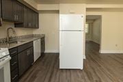 Severn townhouse for rent - A white refrigerator in a kitchen with dark wood floors and cabinets at The Orchards at Severn Townhomes*, Severn, MD 21144.