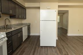 Severn townhouse for rent - A white refrigerator in a kitchen with dark wood floors and cabinets at The Orchards at Severn Townhomes*, Severn, MD 21144.