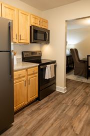 Towson apartment for rent - A kitchen with wooden cabinets and a black refrigerator  at Ivy Hall Apartments*, Maryland, 21204